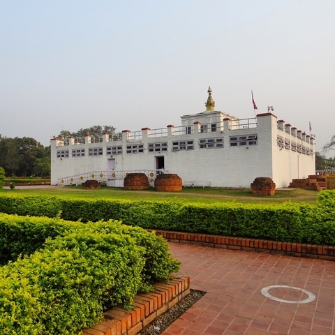 Large white building with garden in front.