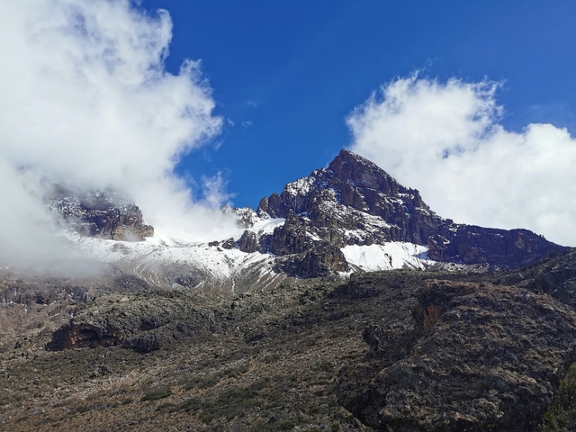       Snow-capped mountain peak with clouds.
  