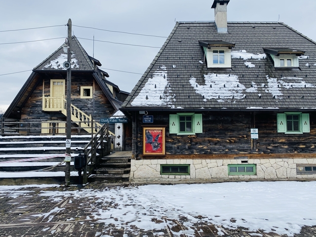       Rustic wooden houses with snow patches on the roof.
  