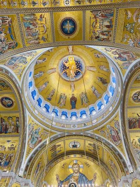       Ceiling of a church with intricate mosaics and religious icons.
  