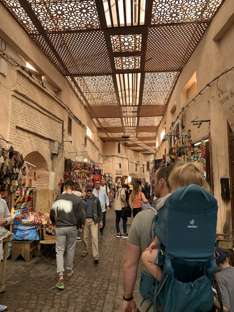 Busy indoor market scene with various goods and people.