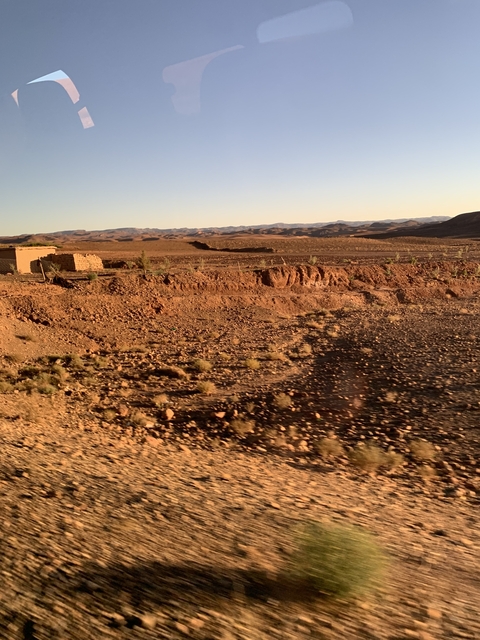      Desert landscape with rough terrain and distant mountains.
  