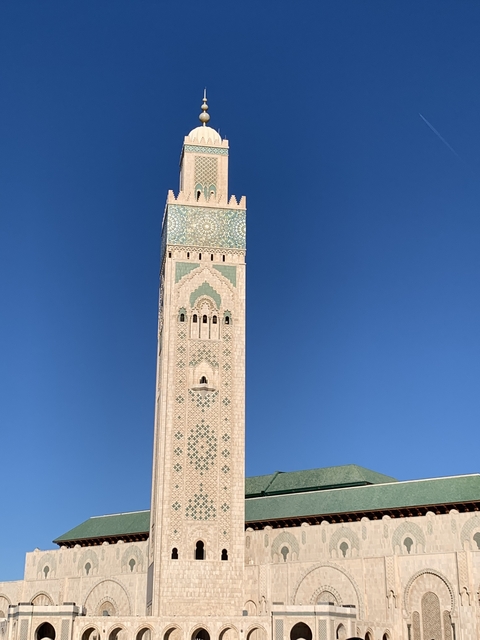       Tall minaret tower under a clear blue sky.
  