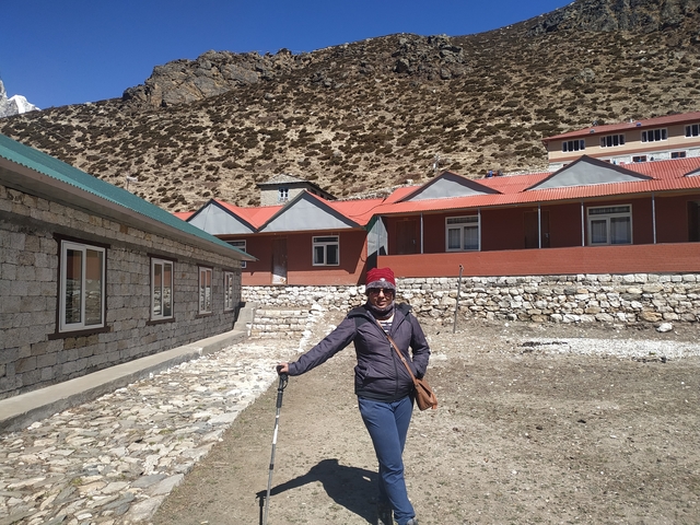 Person in mountain village setting with buildings around.
