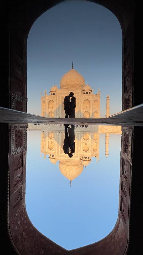 Two people standing in a historic archway.