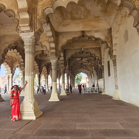 Corridor of historic site with people walking.