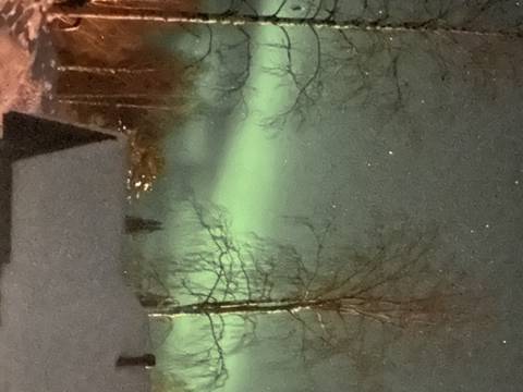 Blurred image of the northern lights over a snowy area.