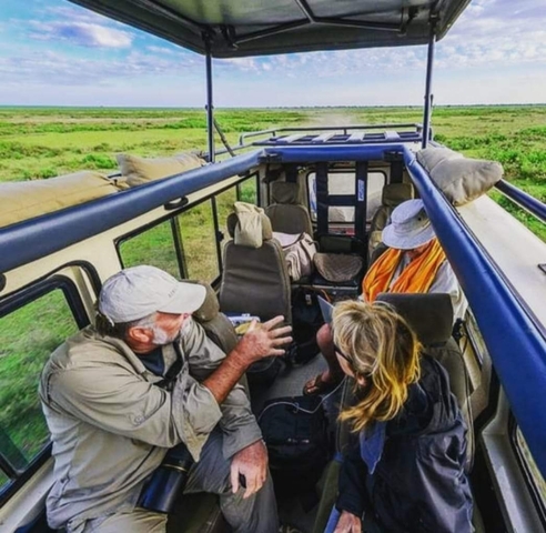 People inside a safari vehicle having a conversation.