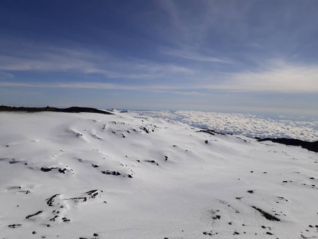       Snow-covered landscape with a view of the clouds.
  