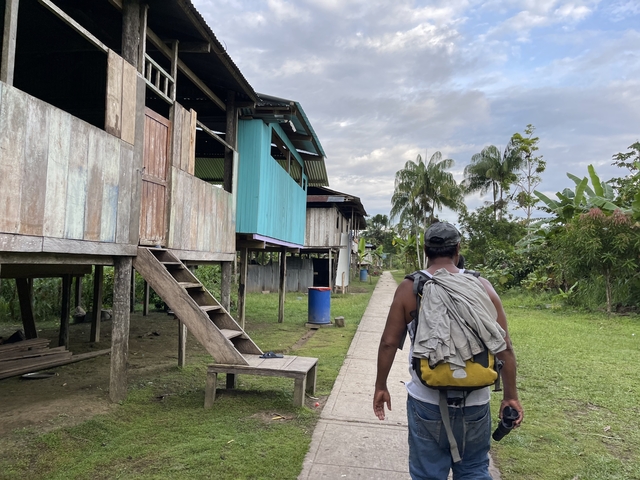 Person walking past elevated wooden houses.
