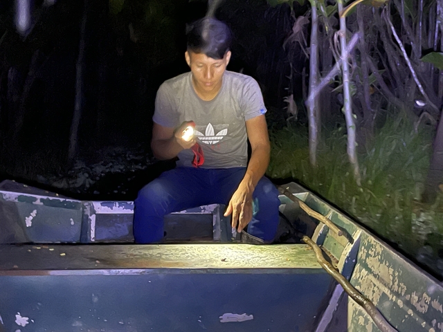 Person in a boat during a nighttime experience.