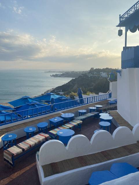 A scenic terrace with blue decor overlooking a body of water.
