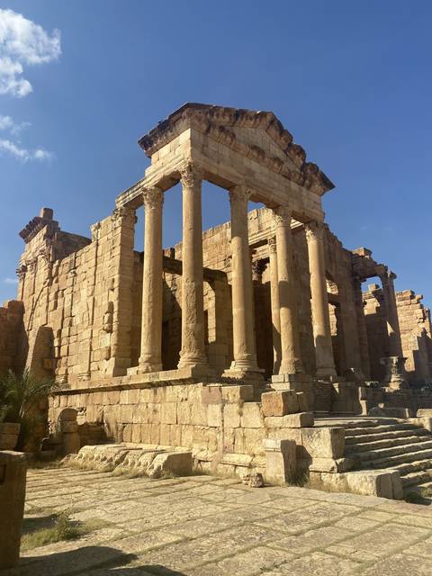       Ruins of an ancient temple with columns under clear skies.
  