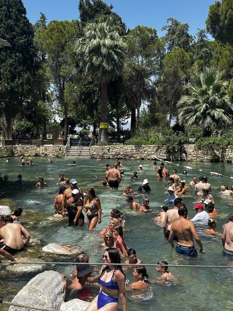       Crowded thermal pool with swimmers.
  