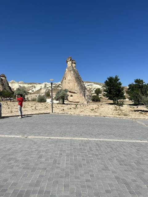Rock formation on a paved path with clear skies.