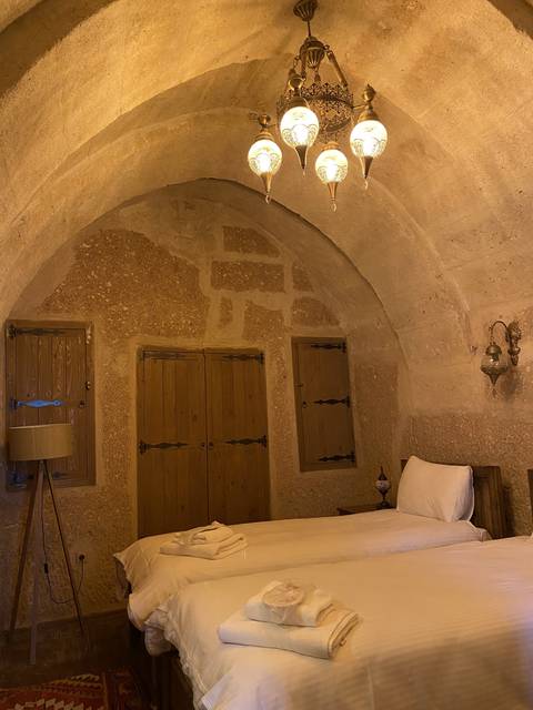       Interior of a cave hotel room with a bed.
  
