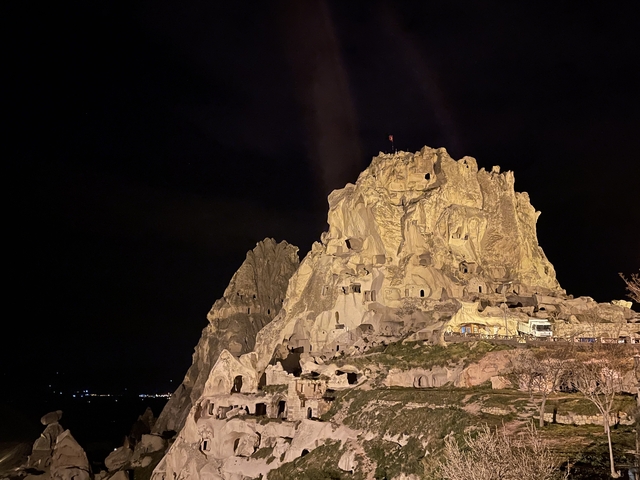       Illuminated rock castle at night.
  