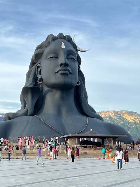 Large statue of a meditative figure with people around.