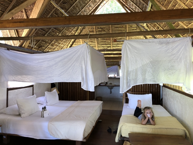 Child lying on a bed in a rustic accommodation setting