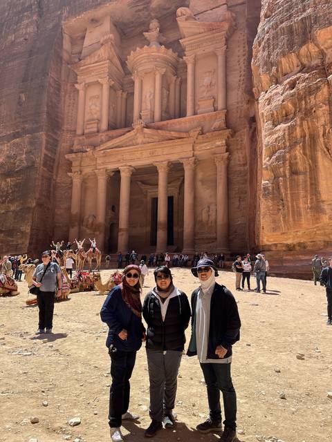 Visitors posing in front of the ancient rock-cut architecture.