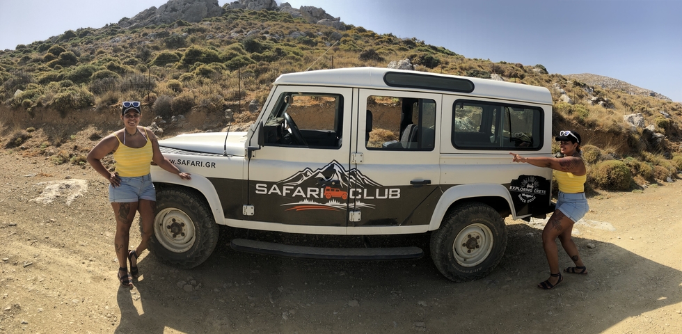       Two people posing next to a safari vehicle.
  