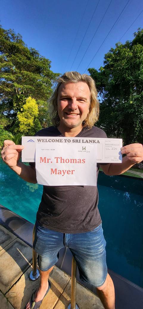       A person holding a sign with a pool in the background.
  