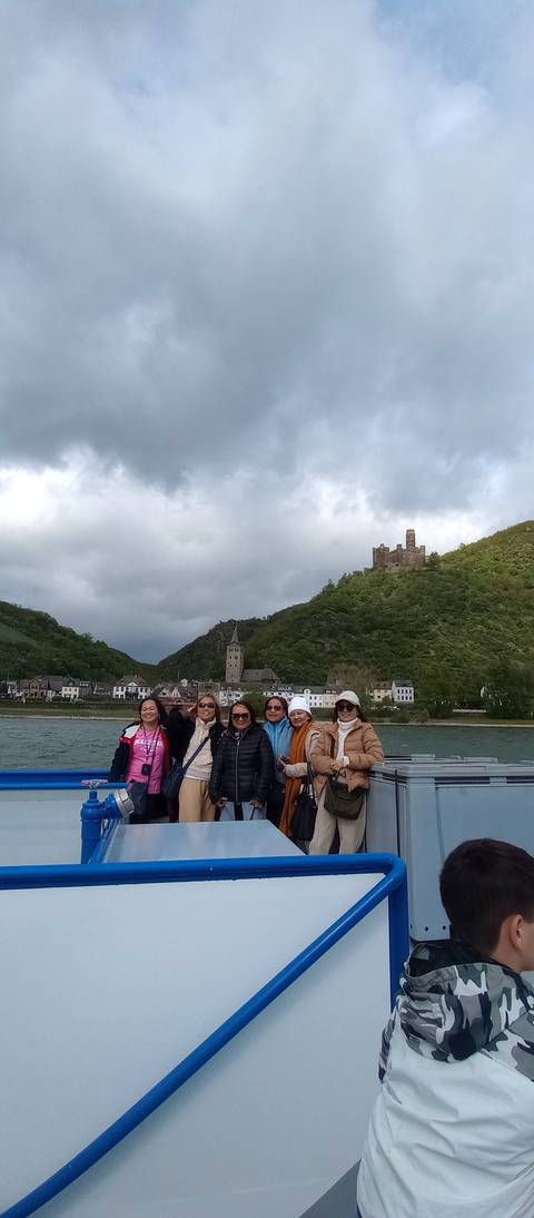 Group of people on a boat with scenic views of hills.