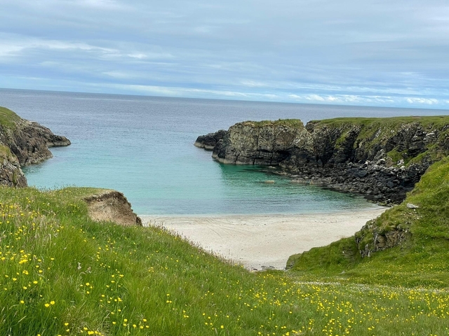Scenic view of beach with cliffs and clear water