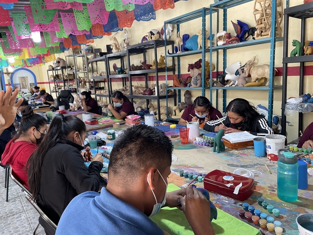       People painting figurines in a workshop
  