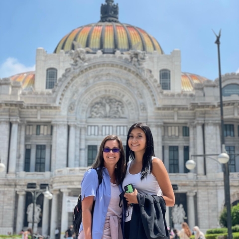       Two women posing in front of Palacio de Bellas Artes
  