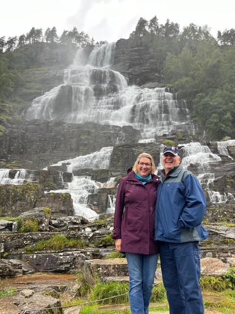 Couple posing in front of a stunning waterfall.