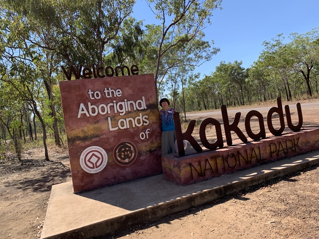       Entrance sign of Kakadu National Park with trees around.
  
