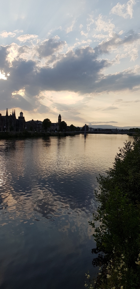       River view at sunset with a bridge and cityscape.
  