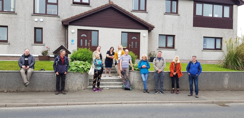       Group of people posing on the steps in front of a building.
  