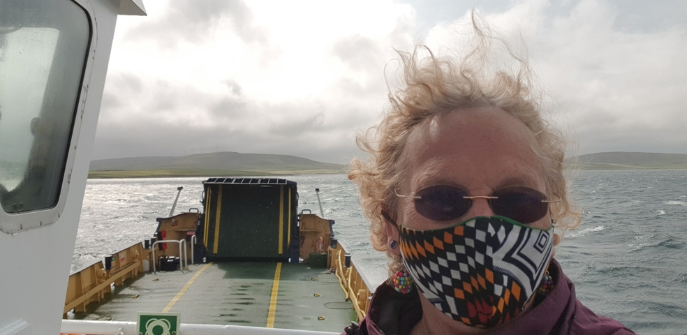       Person on a ferry with land in the distance.
  
