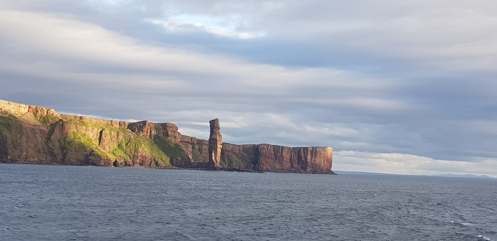       Wide view of sea cliffs with rock formations.
  