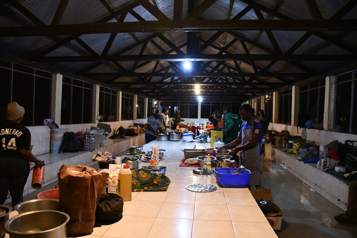       Indoor dining space with people preparing food.
  