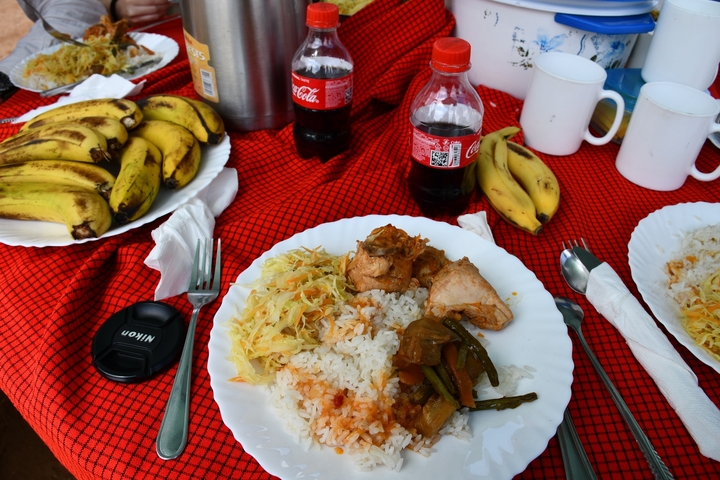       Table with a variety of food including rice, chicken, bananas, and sodas.
  