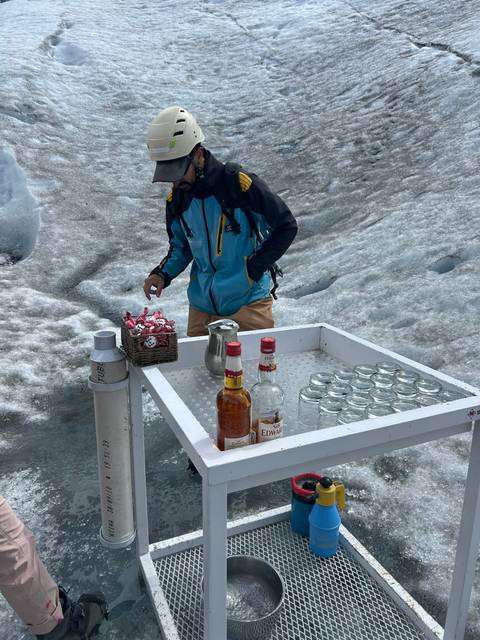 A person working at a makeshift bar on snowy terrain.