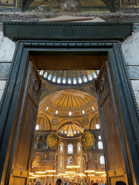       View into the interior of a historic building through large doors.
  