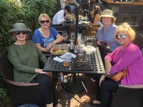 Group of people at a restaurant table outdoors.