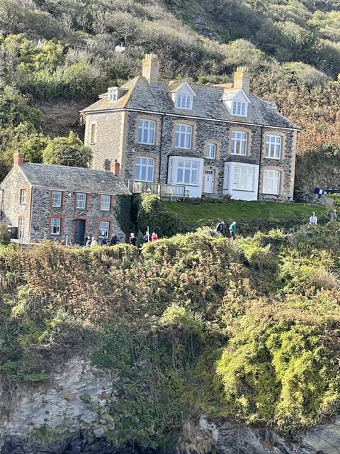 Stone building on a clifftop with plants