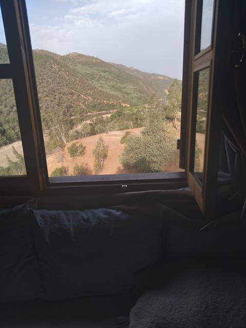 Scenic view from a window overlooking a hilly landscape.