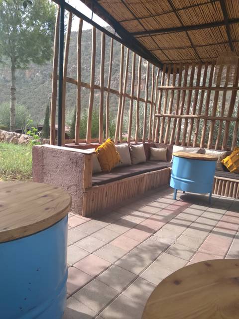 Outdoor lounging area with seating and tables overlooking nature.