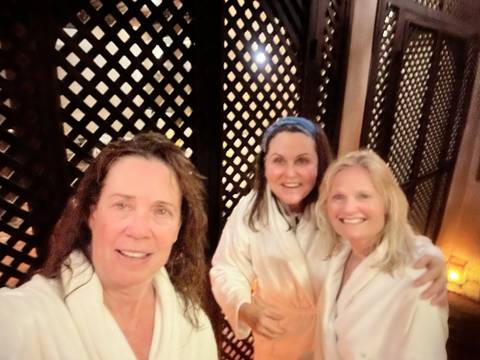       Three people posing indoors with a decorative background.
  