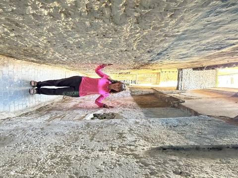 Person in a narrow street with walls on both sides.