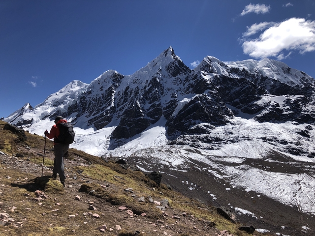 Mountain climber near snow-capped peaks.