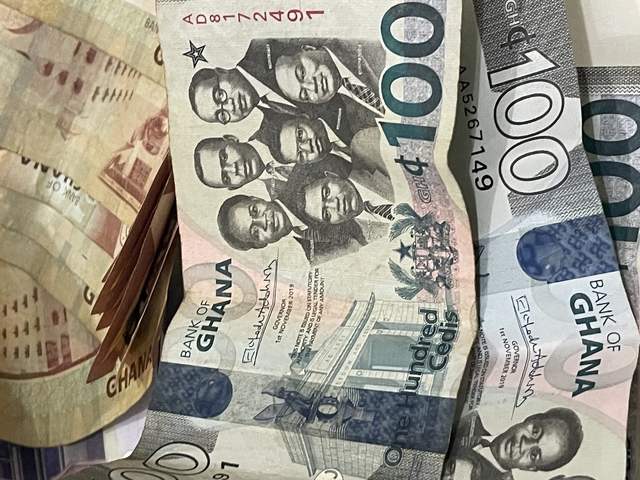 Ghanaian currency on a surface.