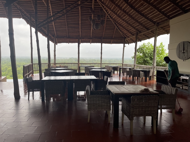 Open-air dining area with person cleaning.