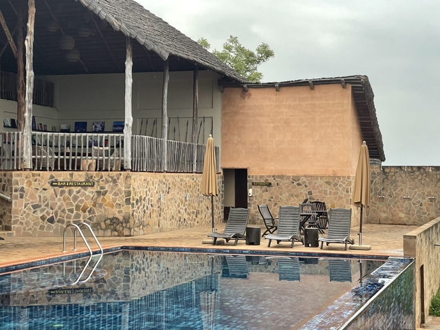 Lounge chairs by a pool and a building.